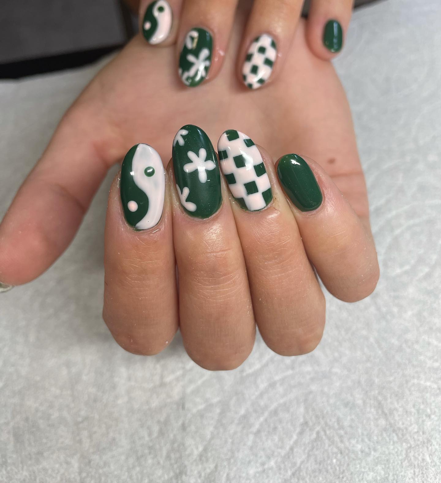 ¿Quién puede decir no a una mezcla de dama, flores y uñas ying yang?  Definitivamente tendrás un estilo diferente con esto.  El esmalte de uñas blanco también combina bien con el verde oscuro.