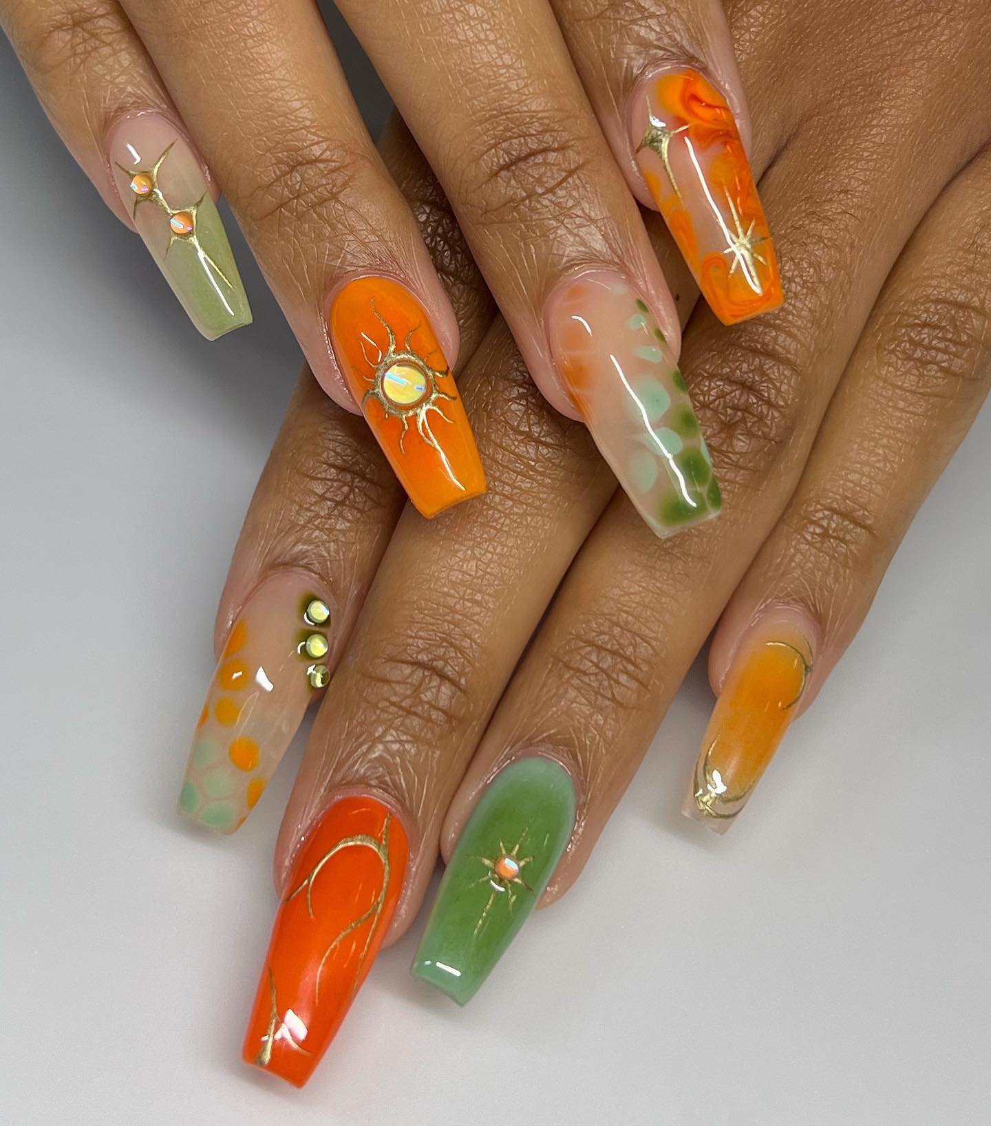 Arte de uñas abstracto multicolor con elementos celestiales en uñas acrílicas largas con forma de ataúd