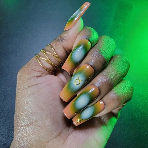 Efecto degradado de aura verde y blanca con arte de uñas con el signo de Tauro en uñas acrílicas largas y cónicas de forma cuadrada