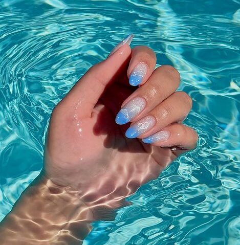 Puntas francesas ombre azul claro con signo de Leo y decoración de uñas de constelaciones en uñas largas y redondas