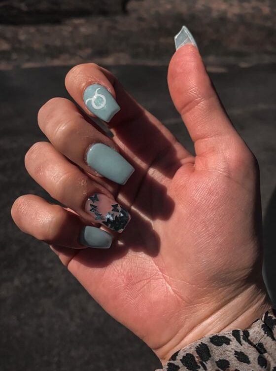 Color de uñas azul claro con arte de uñas del signo de Tauro en uñas cuadradas largas y cónicas