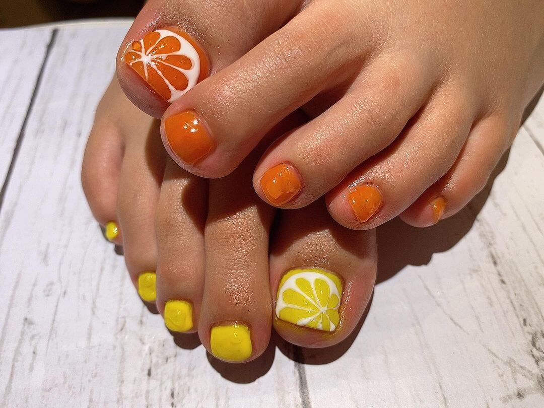 Pedicura única con patrón de naranja y limón.