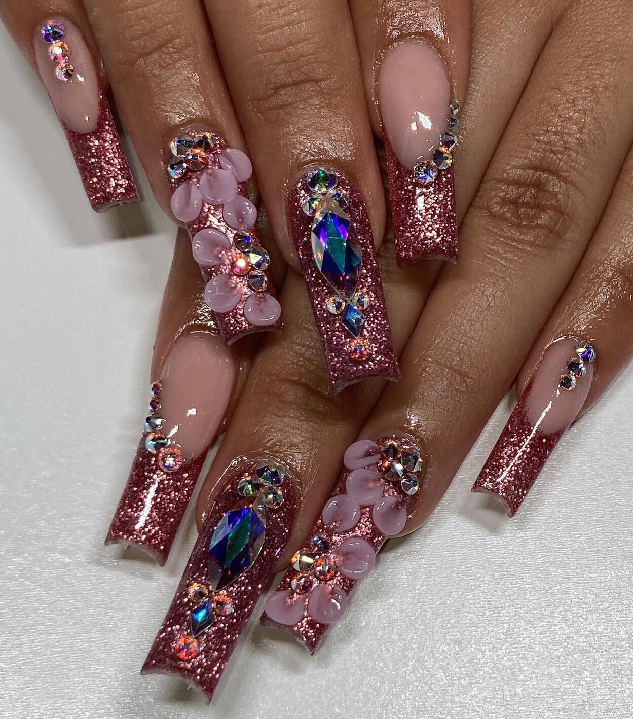 Uñas acrílicas largas y cuadradas con brillantes brillos, pedrería y gemas de oro rosa