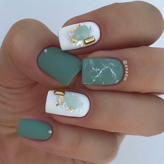 Esmalte de uñas verde y blanco con acabado mate con puntas doradas y arte de uñas de mármol en uñas cortas y cuadradas.