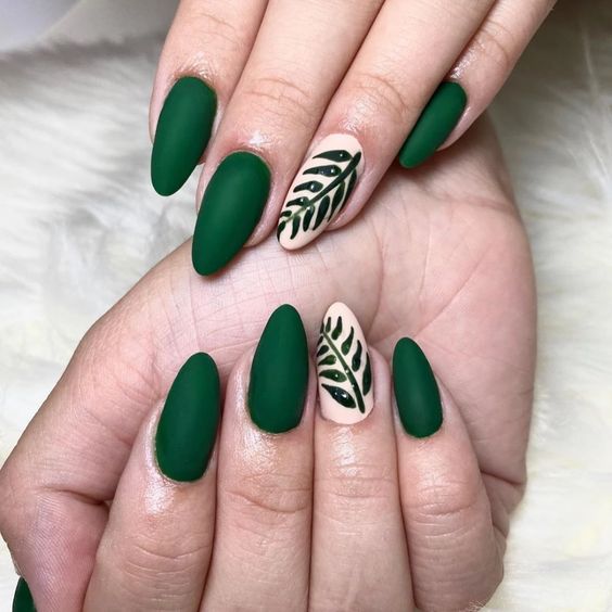 Color de uñas verde oscuro con acabado mate y decoración de uñas en uñas largas y redondas.