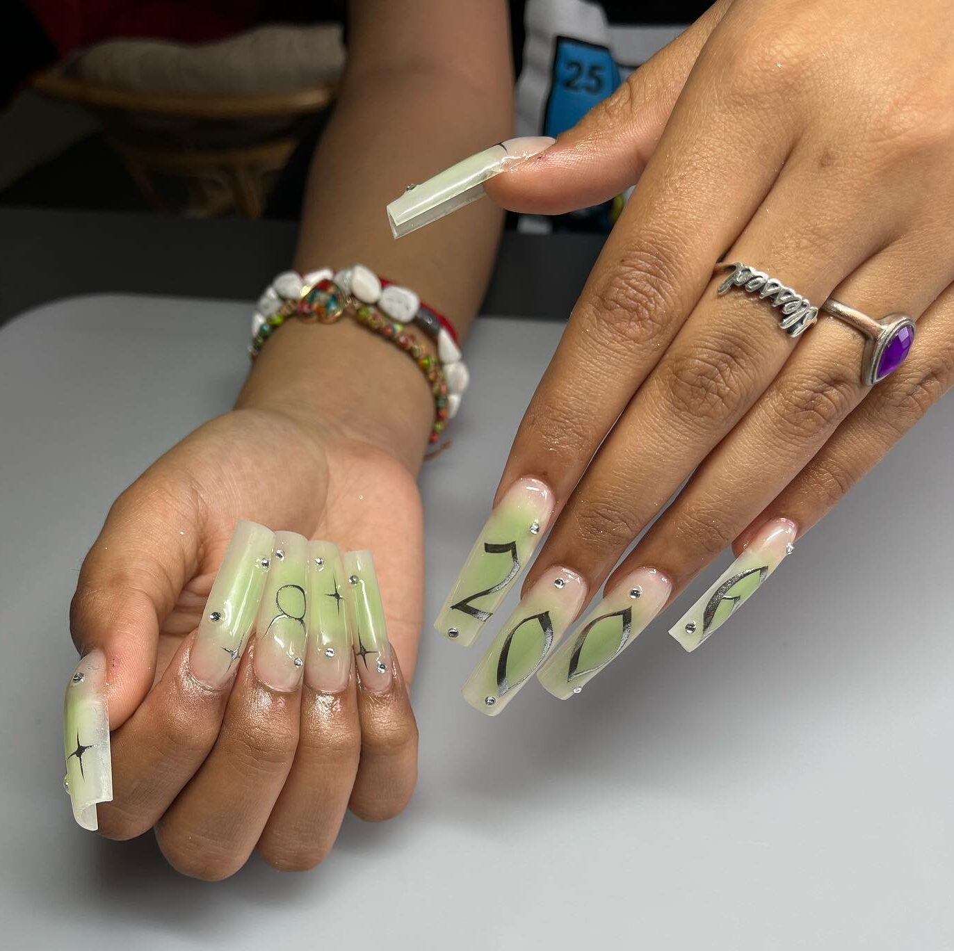 Arte de uñas con degradado de aura verde con el signo de Tauro y elementos celestiales en uñas acrílicas cuadradas súper largas