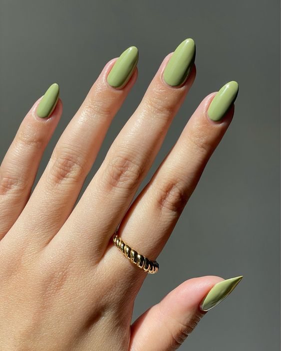 Esmalte de uñas verde claro liso y simple en uñas largas y redondas.