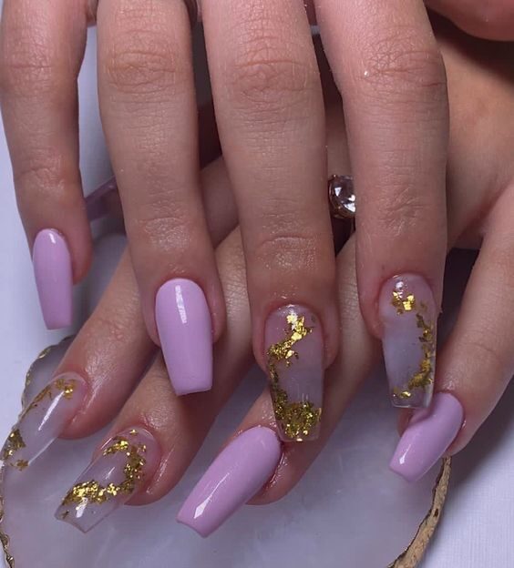 Esmalte de uñas color lavanda y diseño de uñas con lámina dorada en uñas largas de ataúd