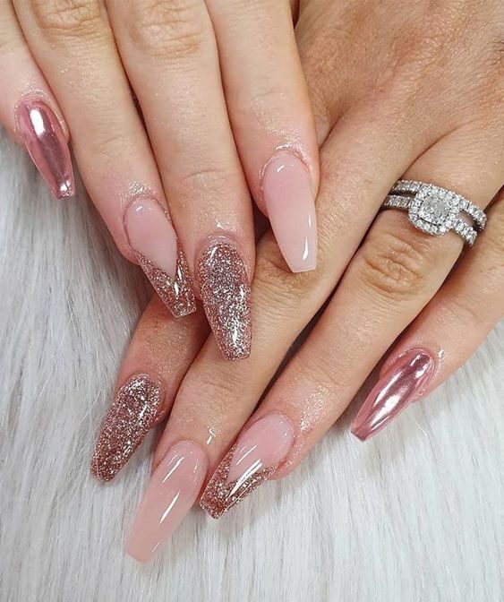 Uñas acrílicas largas en forma de ataúd con brillos en oro rosa