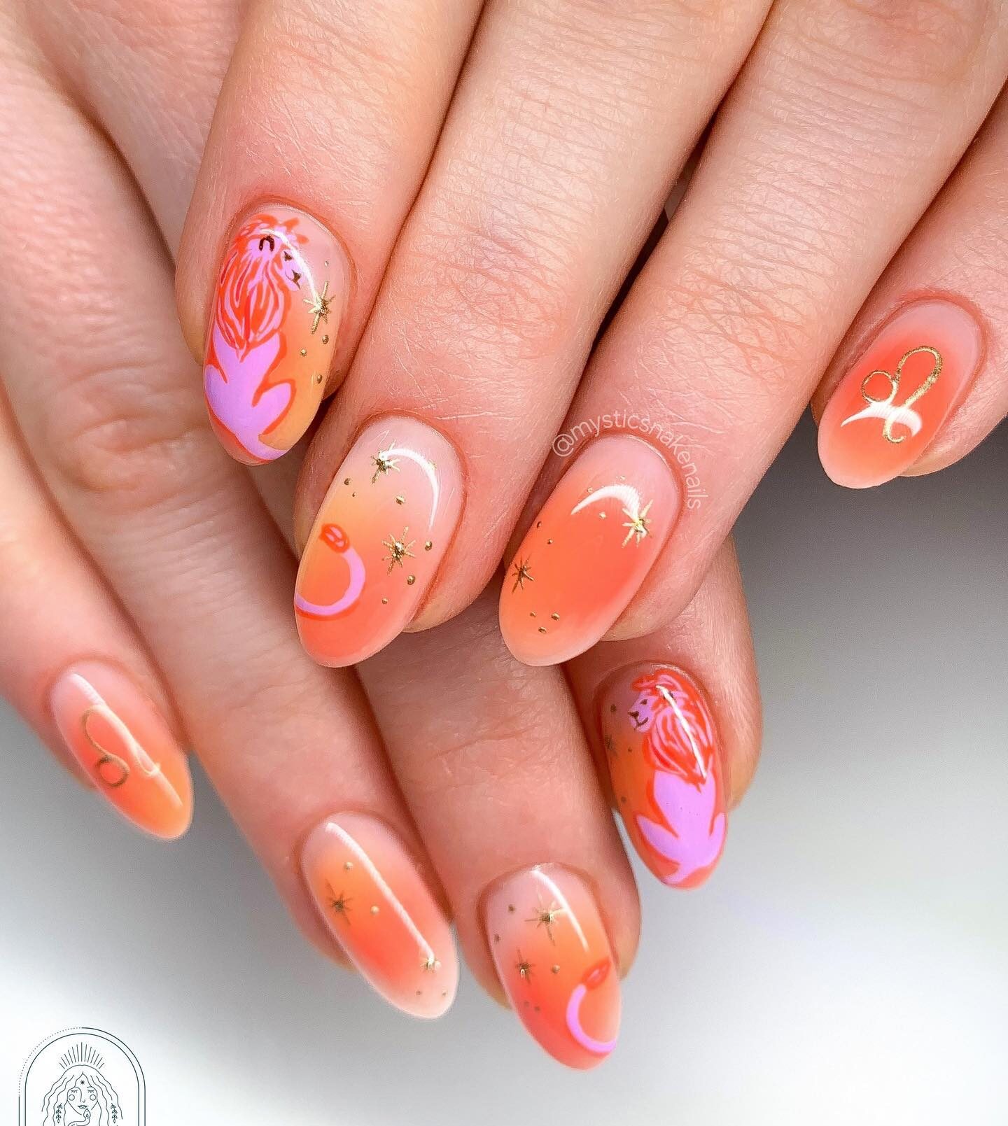 Arte de uñas ombre naranja con diseños de uñas con elementos celestes de león y oro en uñas redondas medianas