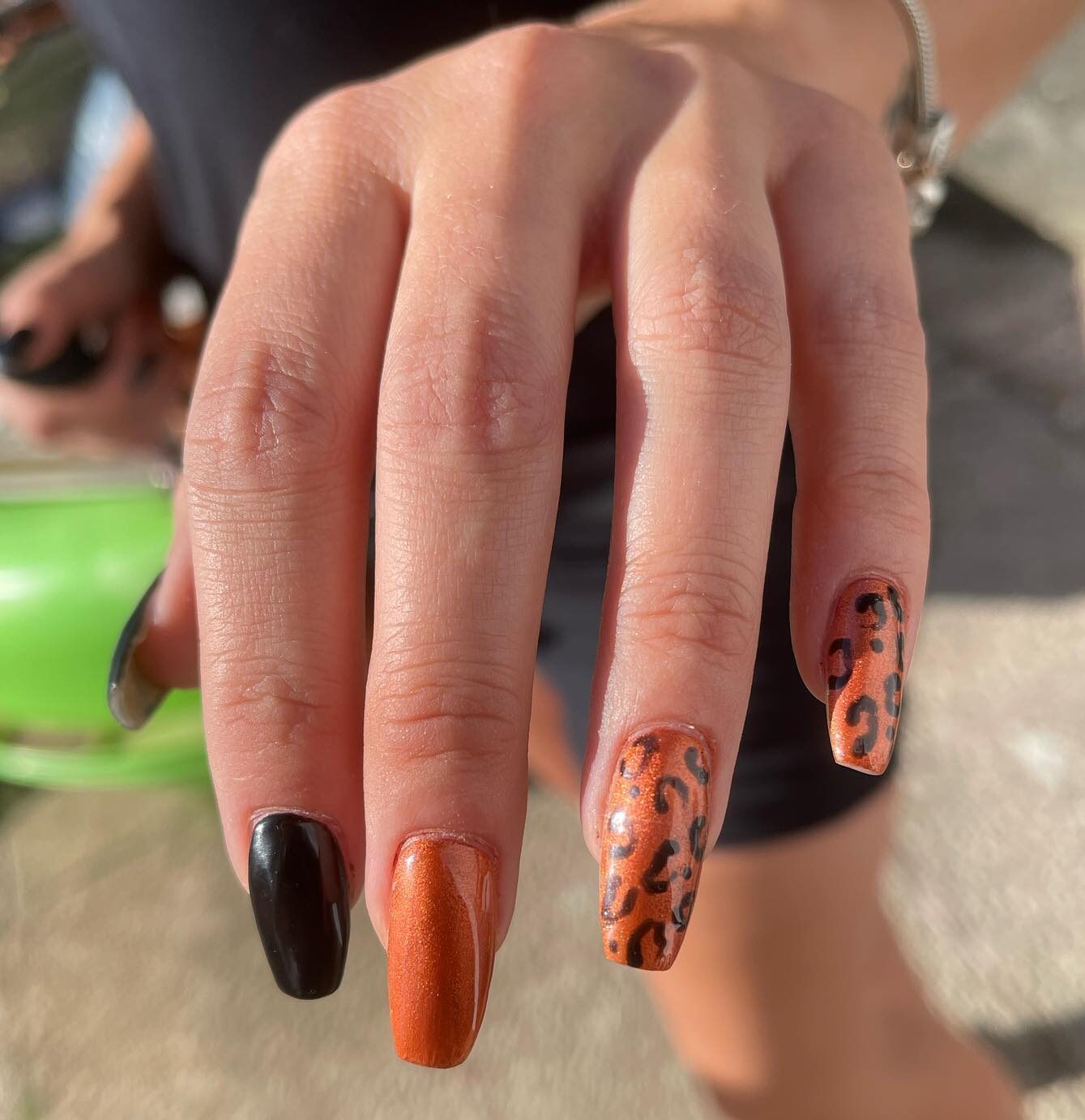 Colores de uñas negro y naranja con estampado de leopardo en uñas largas de ataúd