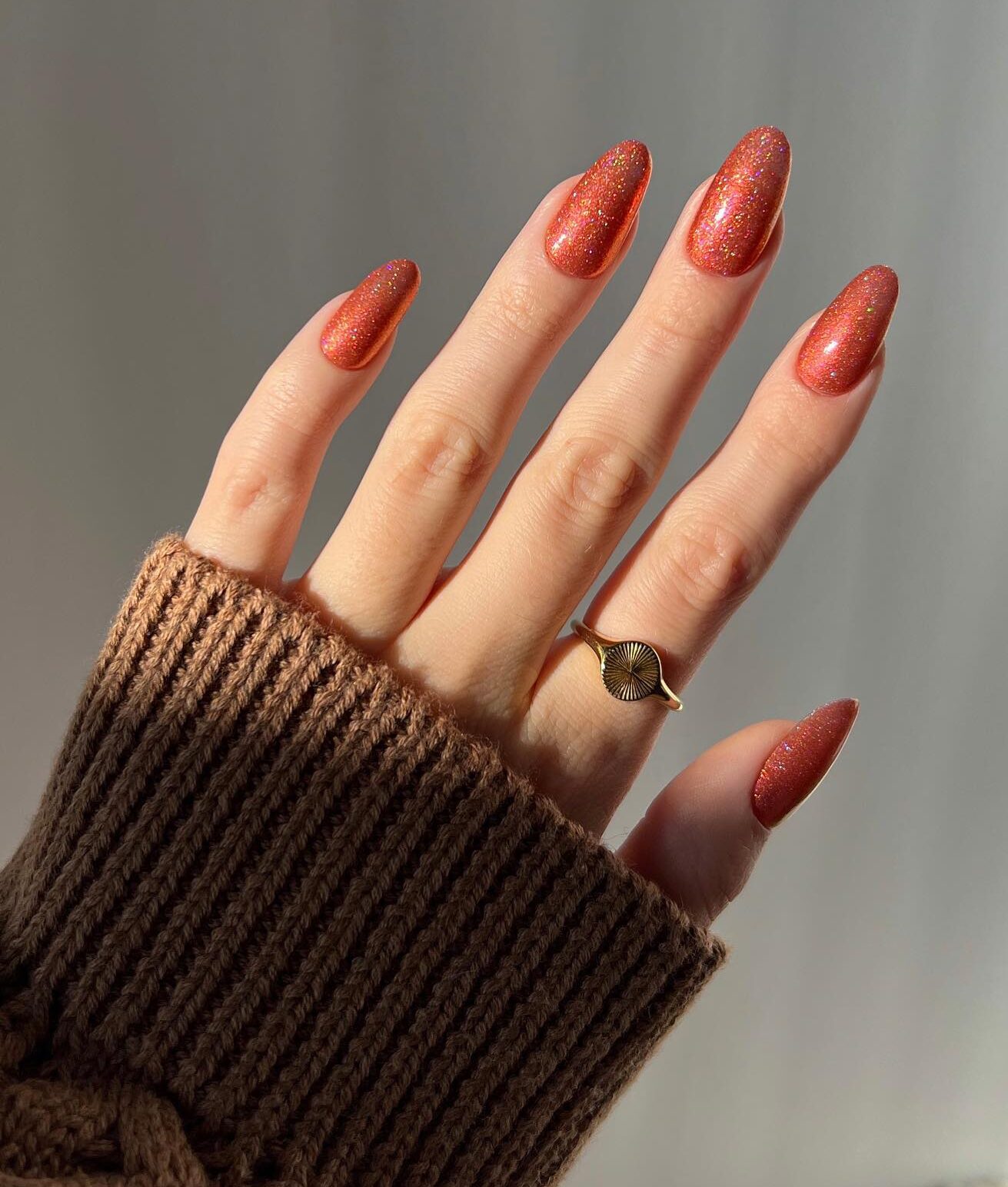 Esmalte de uñas naranja brillante en uñas largas y redondas