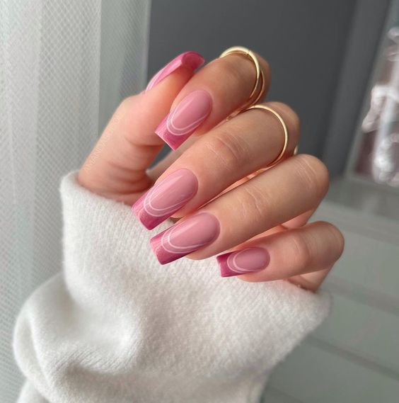 Puntas francesas de color rosa claro en uñas largas y cuadradas.