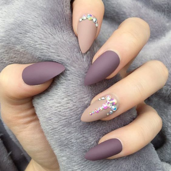 Esmalte de uñas beige y morado en acabado mate con pedrería en uñas stiletto medianas