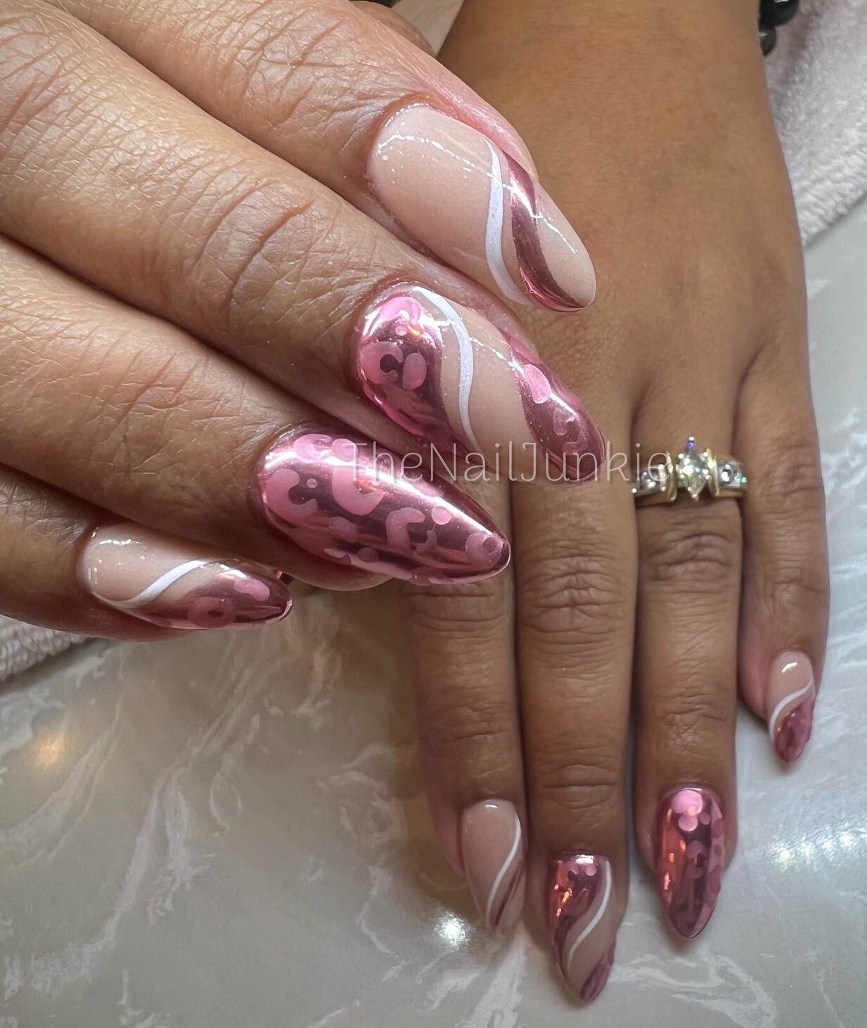 Remolinos cromados en oro rosa y blanco con estampado de leopardo en uñas medianas color almendra