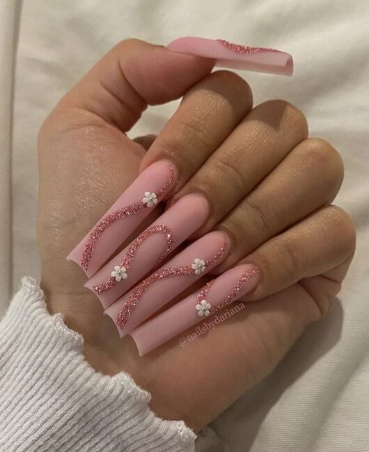 Esmalte de uñas rosa mate con remolinos de oro rosa brillante y flores blancas en 3D en uñas acrílicas cuadradas súper largas