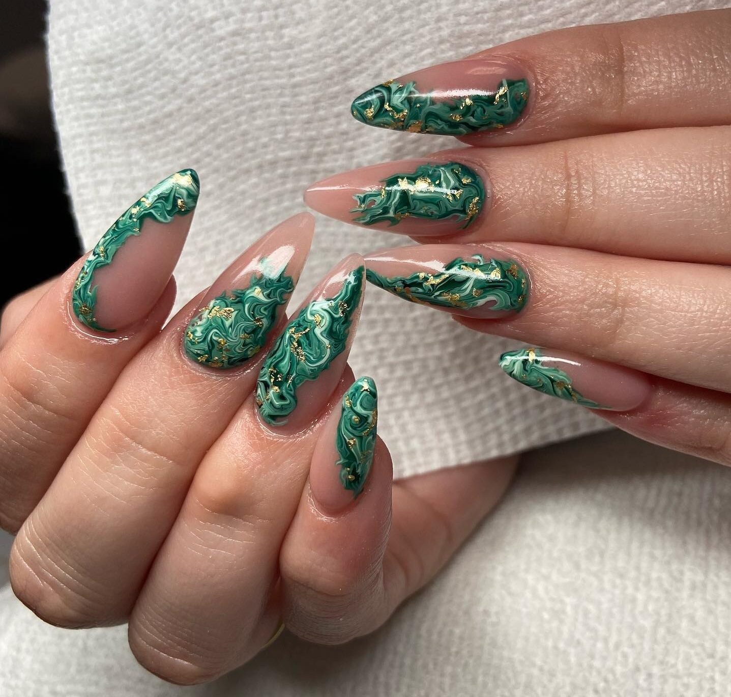 Arte de uñas de mármol verde con detalles en láminas doradas en uñas acrílicas largas con forma de almendra
