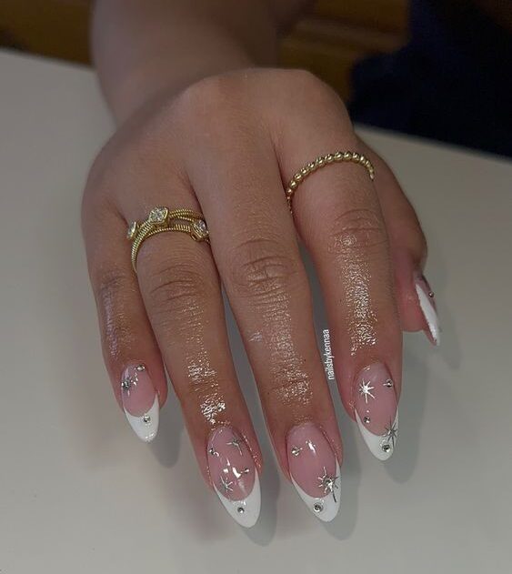 Puntas francesas blancas con uñas celestiales en uñas largas y almendradas.