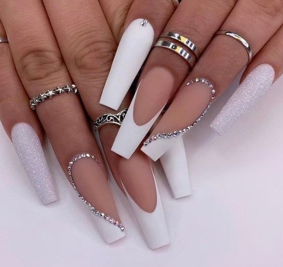 Esmalte de uñas blanco mate con brillos y pedrería en uñas largas de ataúd