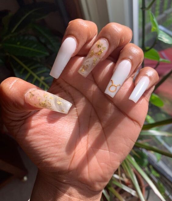 Color de uñas blanco y arte de uñas de mármol blanco con lámina dorada y signo de Tauro dorado en uñas acrílicas largas y cónicas de forma cuadrada.