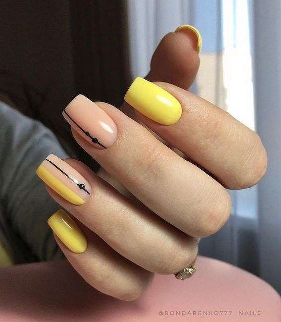 Esmalte de uñas amarillo y líneas negras en uñas cuadradas medianas.