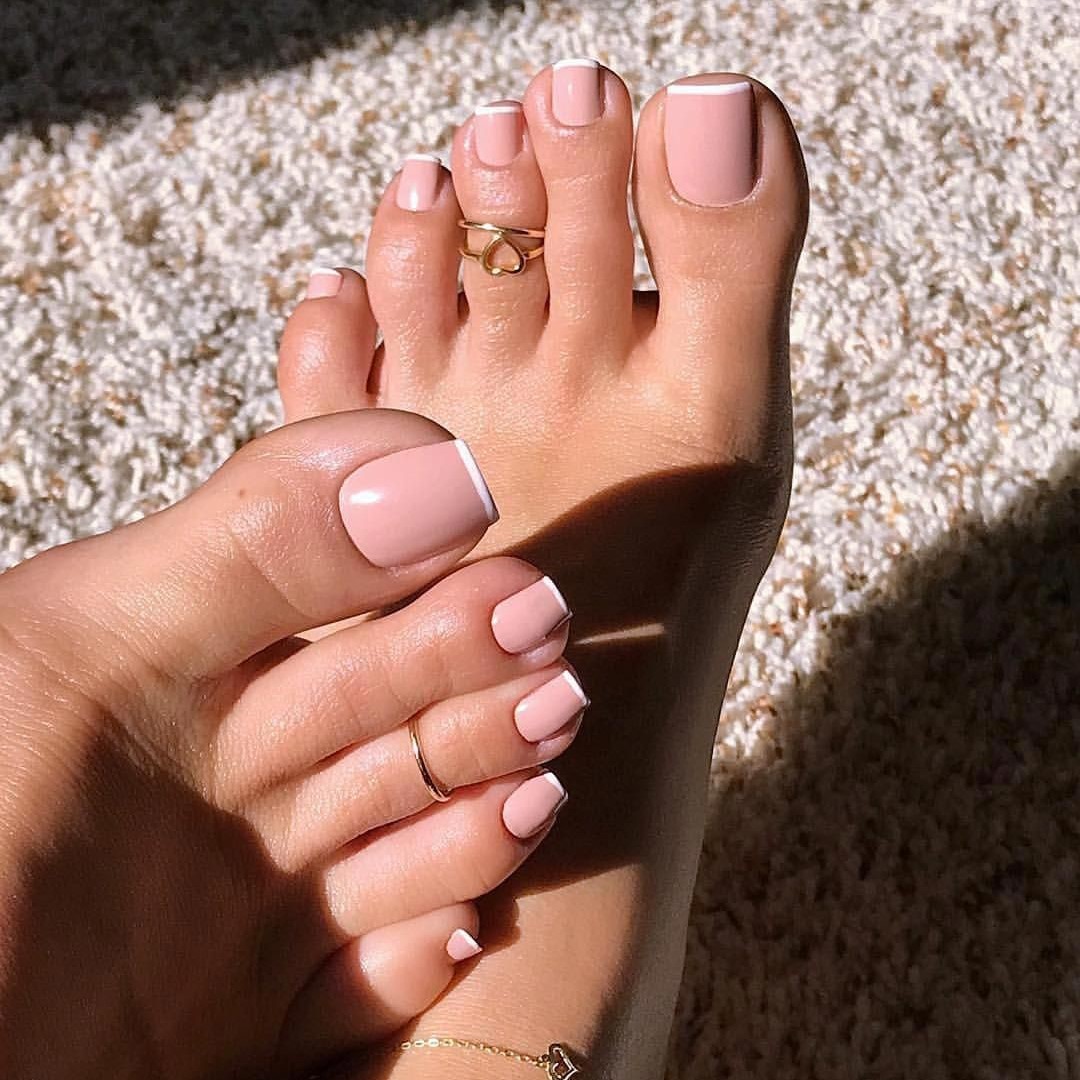 Modelo de pedicura desnuda con esmalte de uñas blanco.