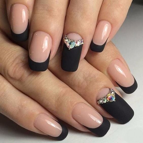 Diseño de uñas francesas en color negro con aplicaciones de piedras