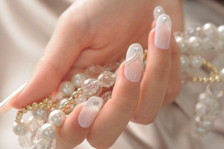 Uñas de color blanco para novia con brillos plateados