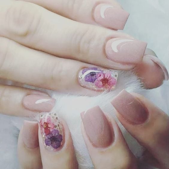 Manicura en tono rosa pastel con decoración de una uña en naturaleza muerta