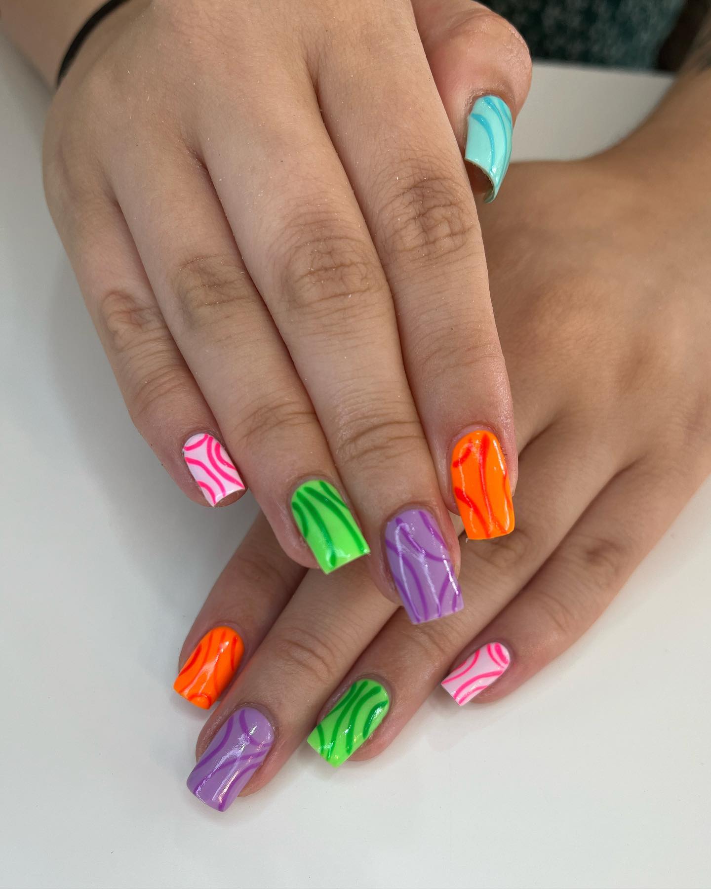 Applying different colors of nail polish on each nail and drawing swirls with the same colors may be a nice way to have this type of nail art.